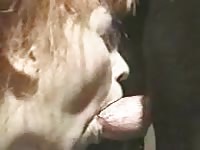Horny old granny sucking on a giant dog cock out side